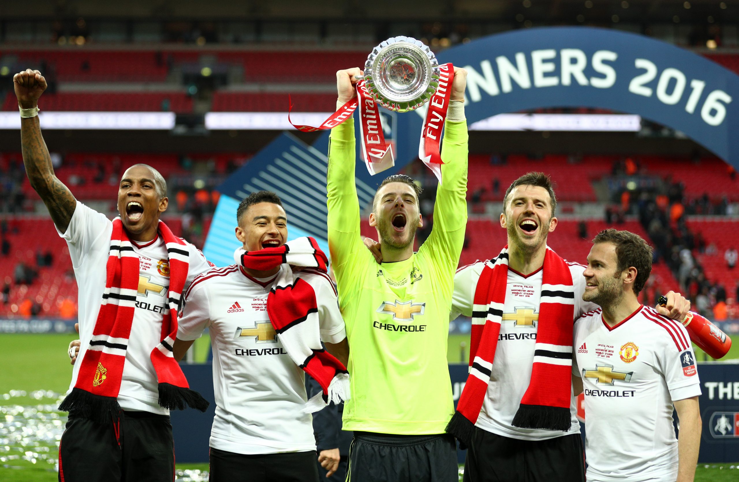 Ashley Young, Jesse Lingard, David De Gea, Michael Carrick and Juan Mata of Manchester United celebrate with the trophy on the pitch after The Emirates FA Cup Final match between Manchester United and Crystal Palace at Wembley Stadium on May 21, 2016. (Photo by Paul Gilham/Getty Images)
