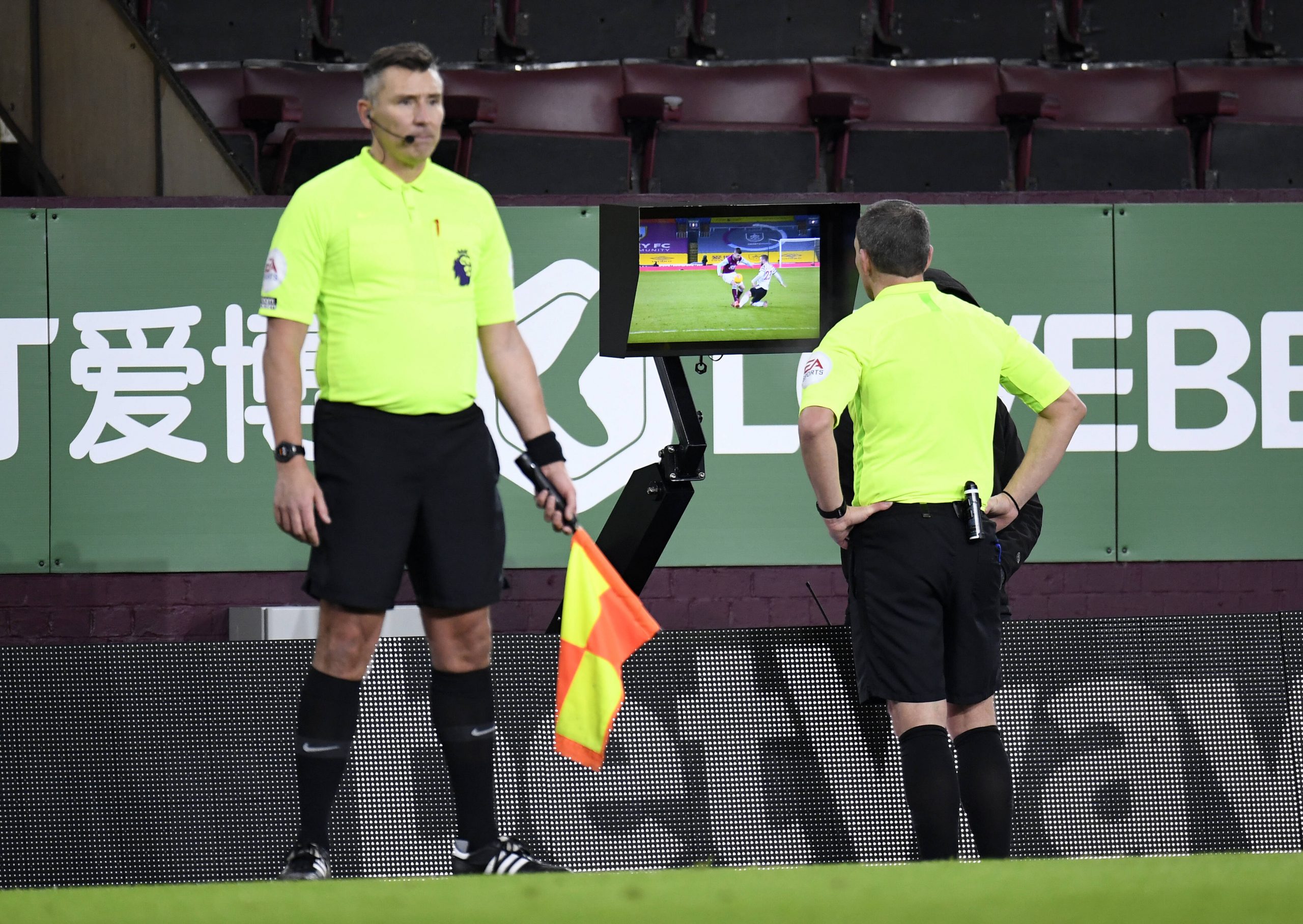 Referee Kevin Friend checks for a foul and consults VAR in a match between Manchester United and Burnley. (imago Images)