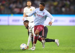 Leon Bailey of Aston Villa and Tyrell Malacia of Manchester United tussle for the ball.