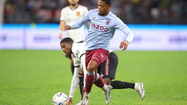 Leon Bailey of Aston Villa and Tyrell Malacia of Manchester United tussle for the ball.