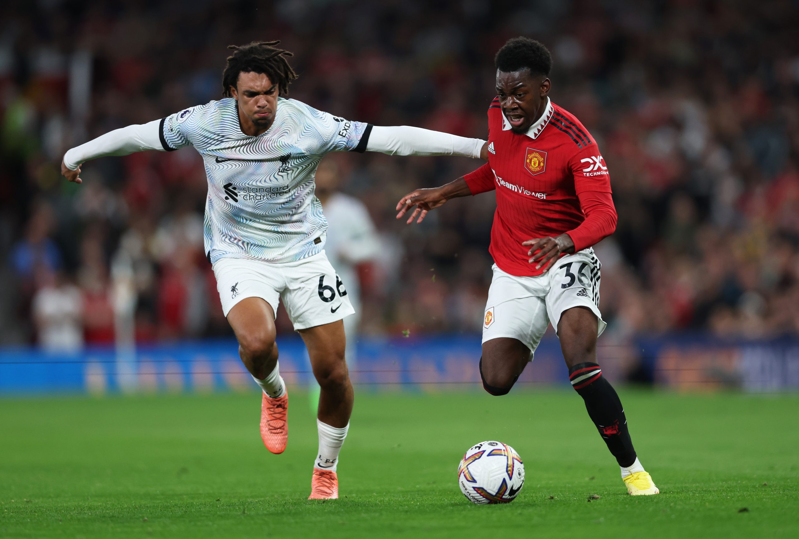 Anthony Elanga of Manchester United is challenged by Trent Alexander-Arnold of Liverpool.