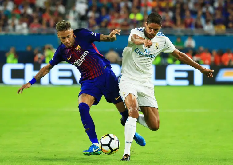 Neymar of Barcelona vies for the ball with Real Madrid's Raphael Varane.