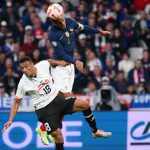 Raphael Varane (R) heads the ball from Austria's Karim Onisiw during a UEFA Nations League game.