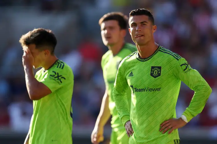 Cristiano Ronaldo and Lisandro Martinez of Manchester United with Harry Maguire blurred out in the background.