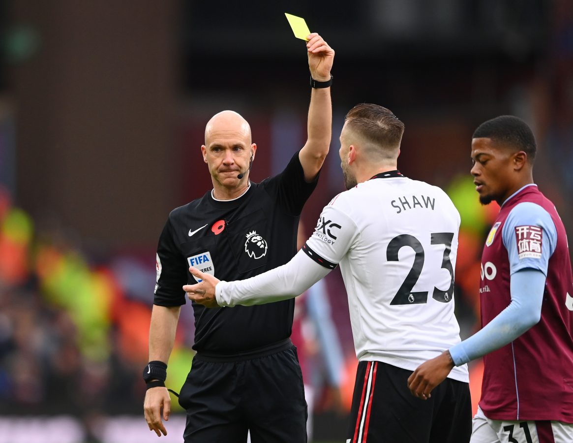 Luke Shaw gets a yellow card as Leon Bailey of Aston Villa watches on during his team's win against Manchester United. 