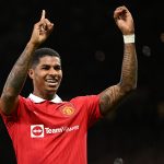 Manchester United's English striker Marcus Rashford indicates it's his 100th Man Utd goal as he celebrates scoring the opening goal of the English Premier League football match between Manchester United and West Ham United at Old Trafford in Manchester, north-west England, on October 30, 2022