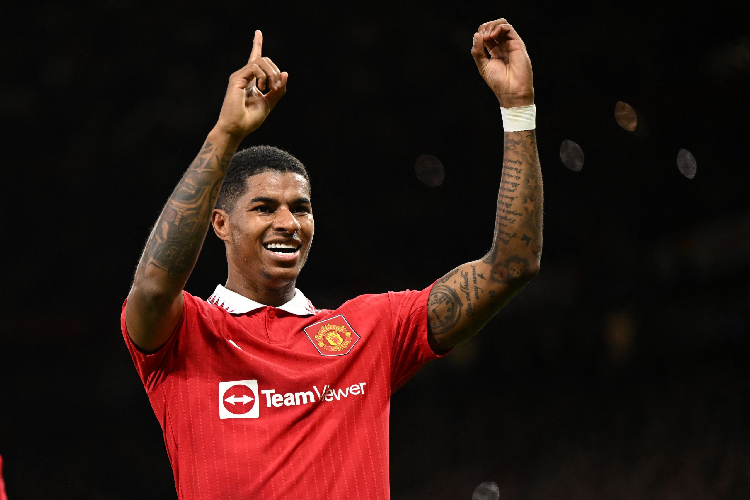 Manchester United's English striker Marcus Rashford indicates it's his 100th Man Utd goal as he celebrates scoring the opening goal of the English Premier League football match between Manchester United and West Ham United at Old Trafford in Manchester, north-west England, on October 30, 2022