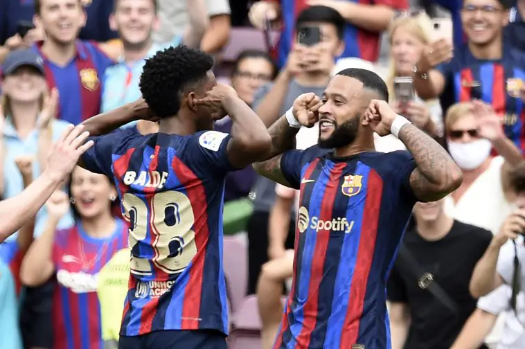 Barcelona's Dutch forward Memphis Depay (R) celebrates scoring his team's second goal during the Spanish League football match between FC Barcelona and Elche CF at the Camp Nou stadium in Barcelona on September 17, 2022.