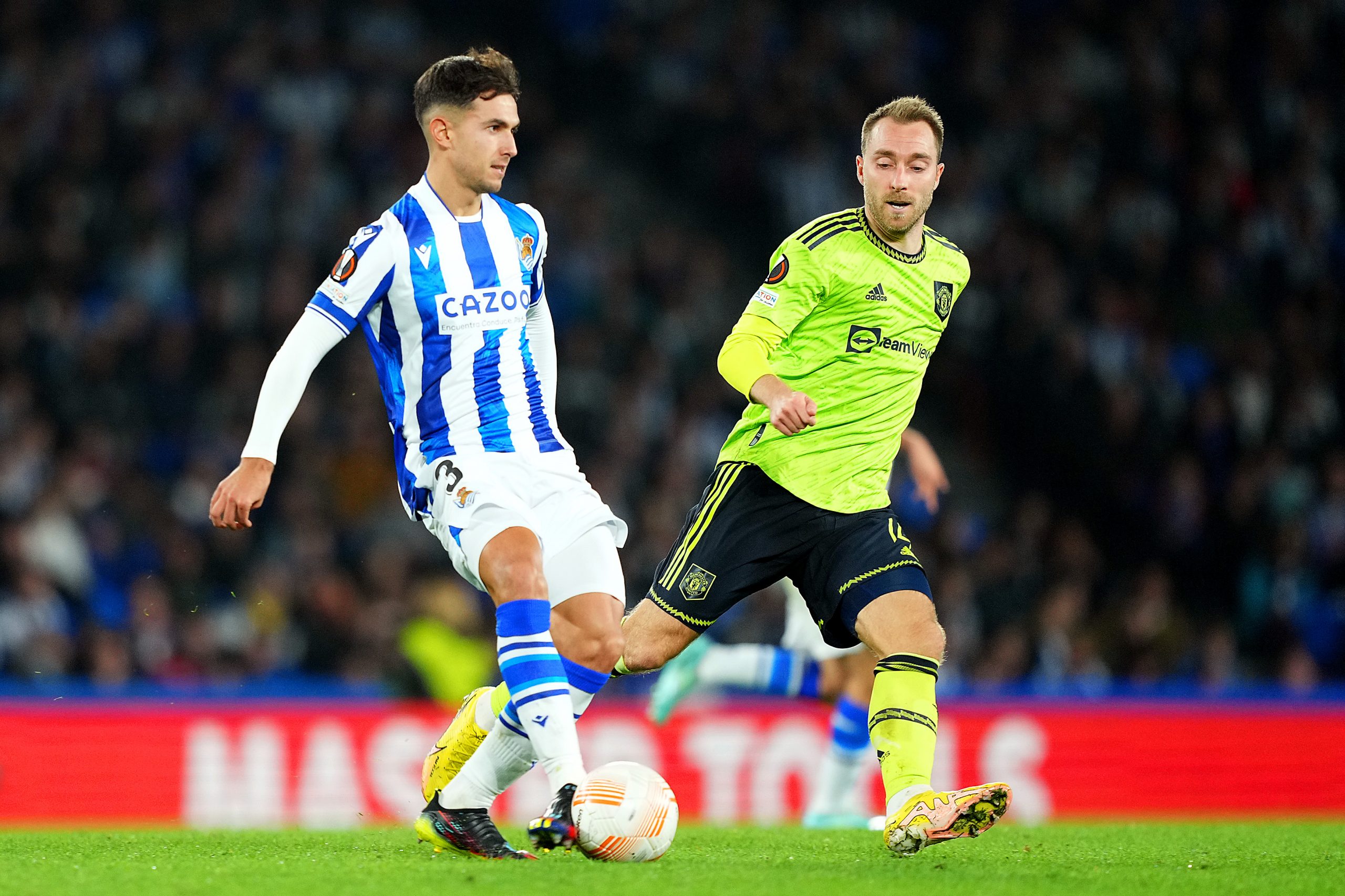 Martin Zubimendi of Real Sociedad is challenged by whilst under pressure from Christian Eriksen of Manchester United during the UEFA Europa League group E match between Real Sociedad and Manchester United at Reale Arena on November 03, 2022 in San Sebastian, Spain