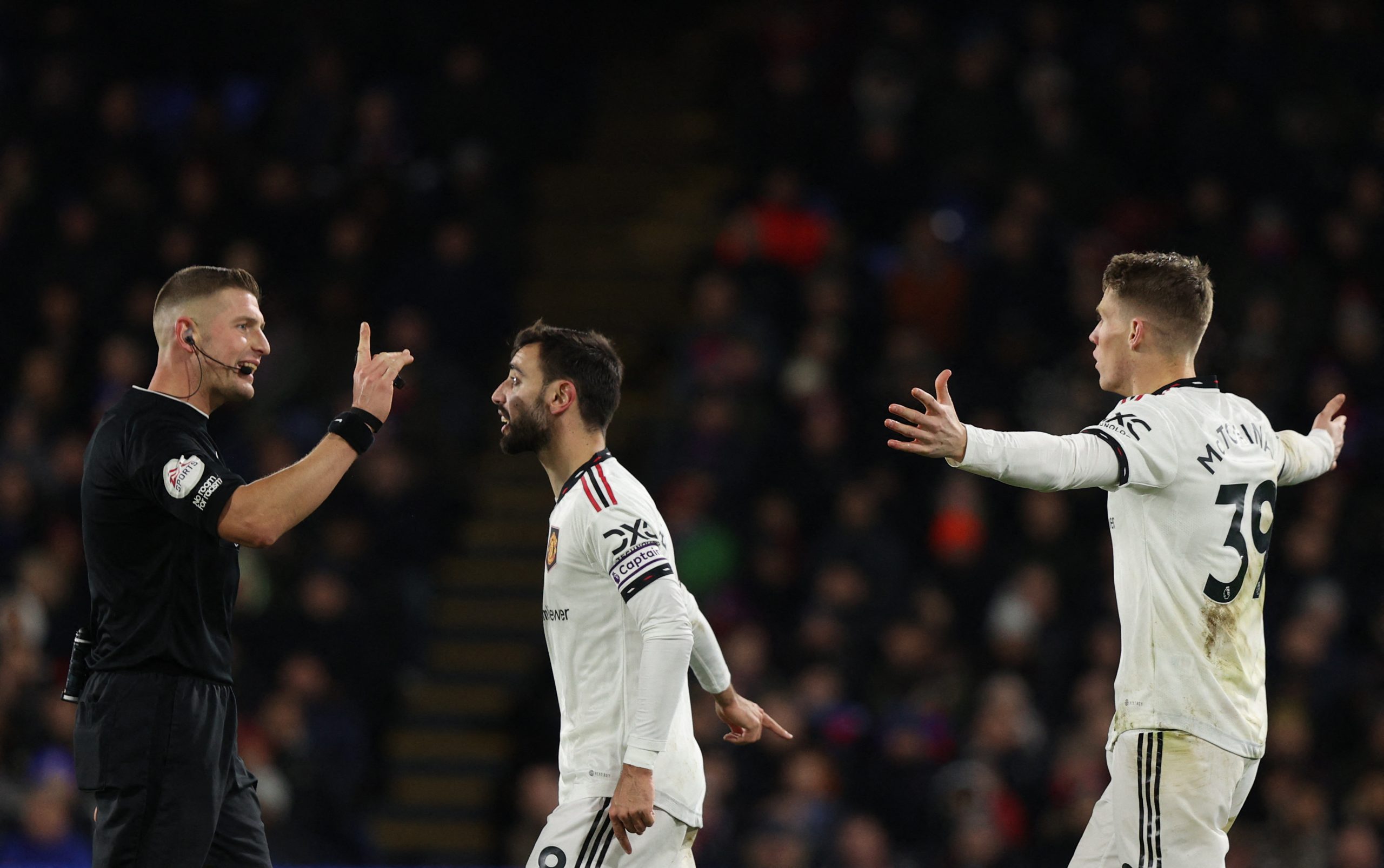 Manchester United's Portuguese midfielder Bruno Fernandes (C) argues with referee Robert Jones (L) following a foul commited on Manchester United's Scottish midfielder Scott McTominay (R) during the English Premier League football match between Crystal Palace and Manchester United at Selhurst Park in south London on January 18, 2023