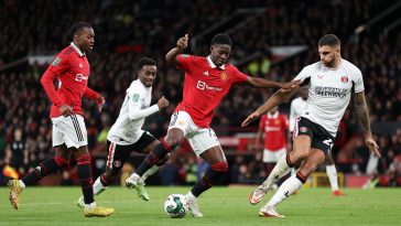 Kobbie Mainoo of Manchester United controls the ball under pressure from Ryan Inniss of Charlton Athletic during the Carabao Cup Quarter Final match between Manchester United and Charlton Athletic at Old Trafford on January 10, 2023 in Manchester, England