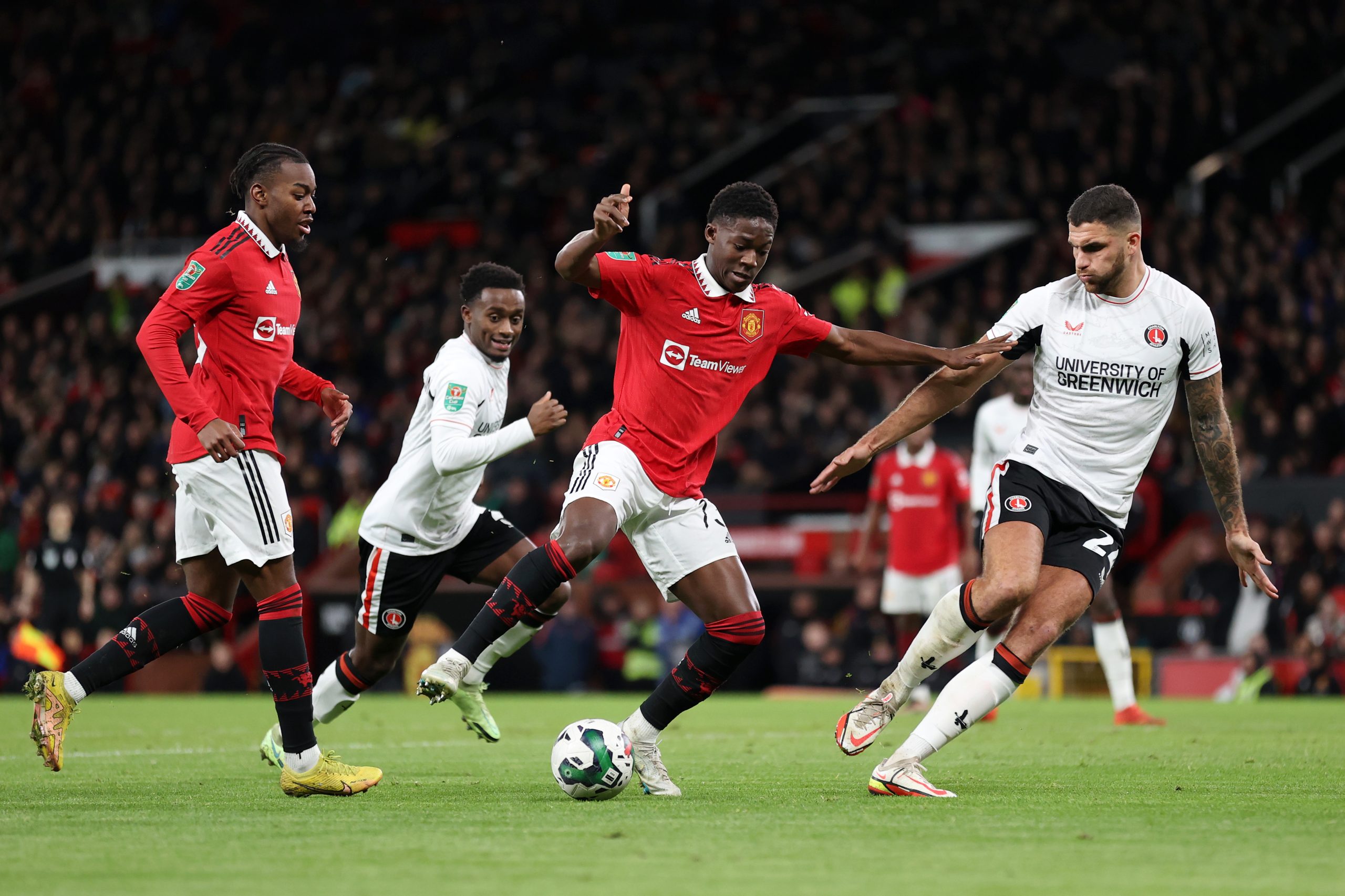 Kobbie Mainoo of Manchester United controls the ball under pressure from Ryan Inniss of Charlton Athletic during the Carabao Cup Quarter Final match between Manchester United and Charlton Athletic at Old Trafford on January 10, 2023 in Manchester, England