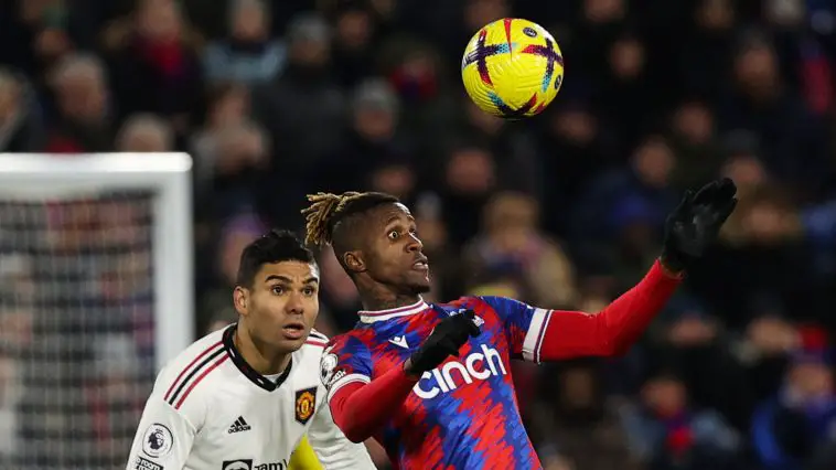 Manchester United's Brazilian midfielder Casemiro (L) eyes the ball as Crystal Palace's Ivorian striker Wilfried Zaha heads it during the English Premier League football match between Crystal Palace and Manchester United at Selhurst Park in south London on January 18, 2023.