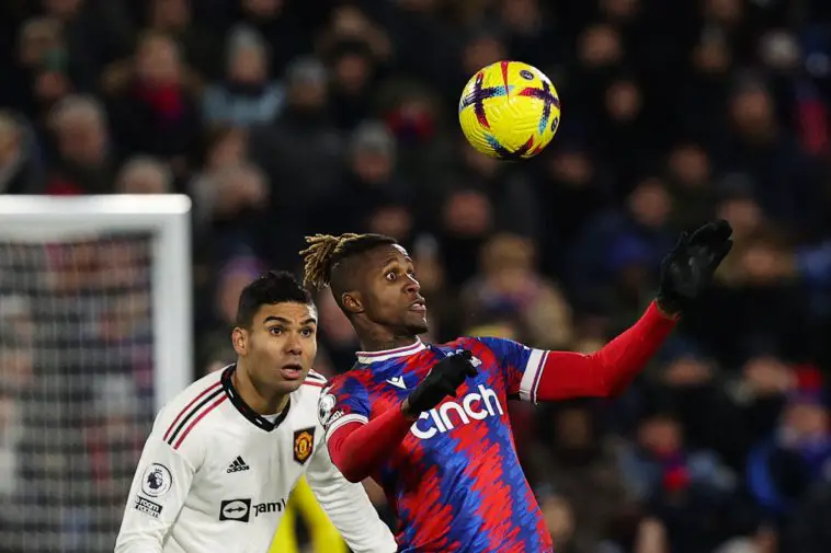 Manchester United's Brazilian midfielder Casemiro (L) eyes the ball as Crystal Palace's Ivorian striker Wilfried Zaha heads it during the English Premier League football match between Crystal Palace and Manchester United at Selhurst Park in south London on January 18, 2023.