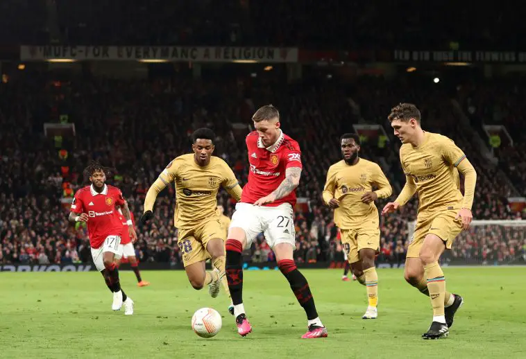 Wout Weghorst of Manchester United passes the ball while under pressure from Alejandro Balde and Andreas Christensen of FC Barcelona during the UEFA Europa League knockout round play-off leg two match between Manchester United and FC Barcelona at Old Trafford on February 23, 2023 in Manchester, England