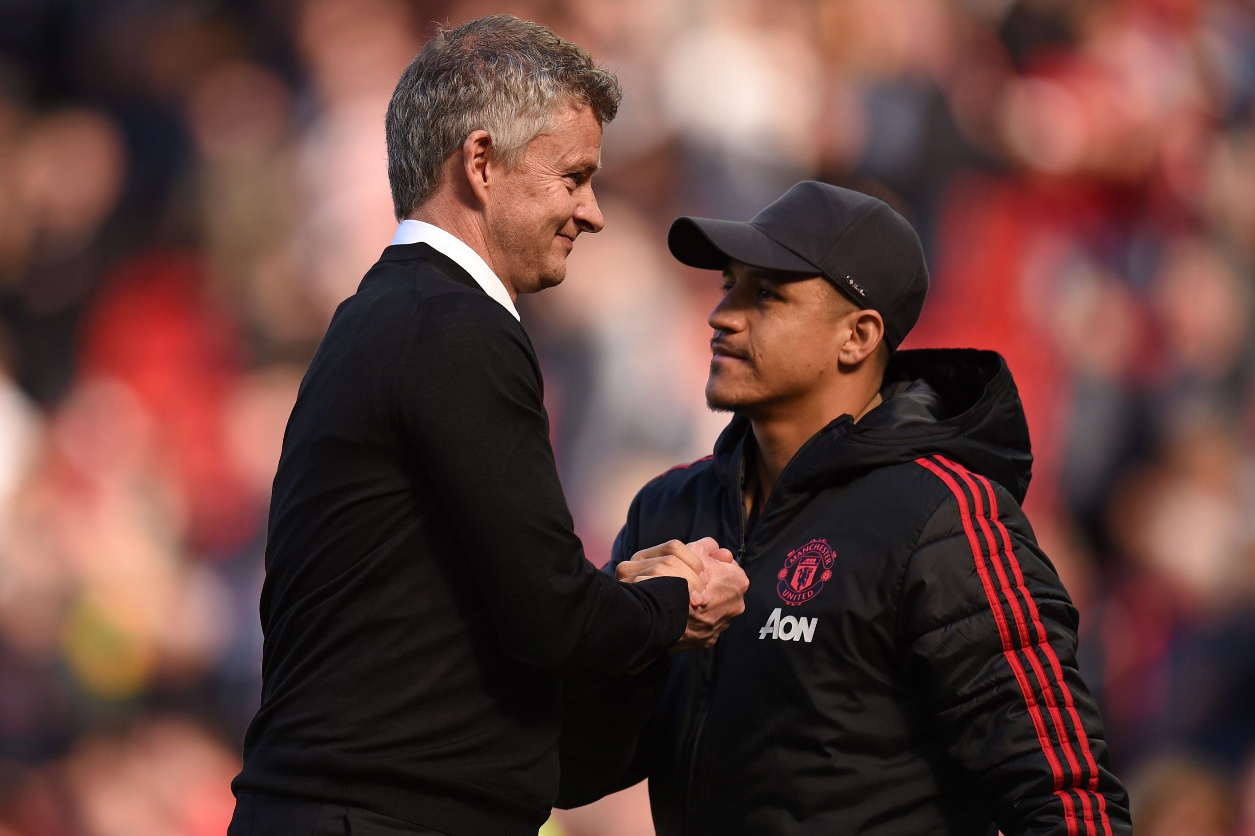 Manchester United's Norwegian manager Ole Gunnar Solskjaer shakes hands with Alexis Sanchez.