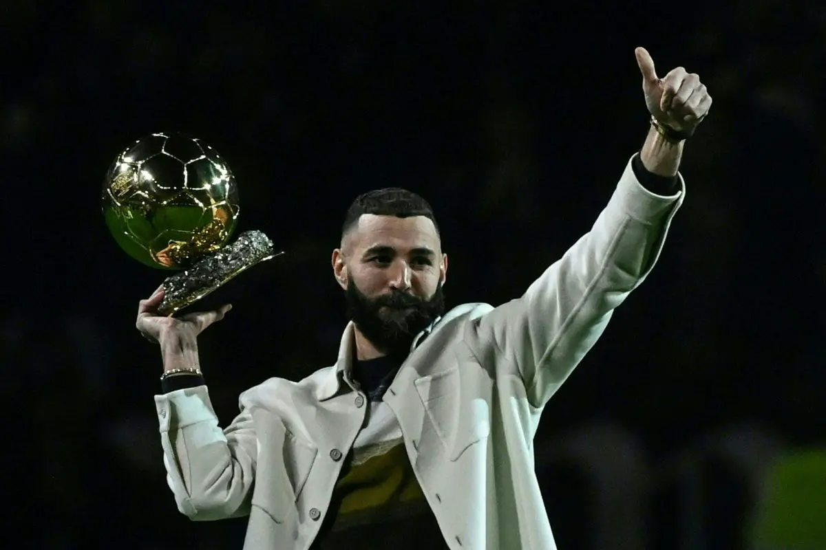 Real Madrid's French forward Karim Benzema poses on the pitch with his Ballon d'Or trophy. (Photo by OLIVIER CHASSIGNOLE/AFP via Getty Images)